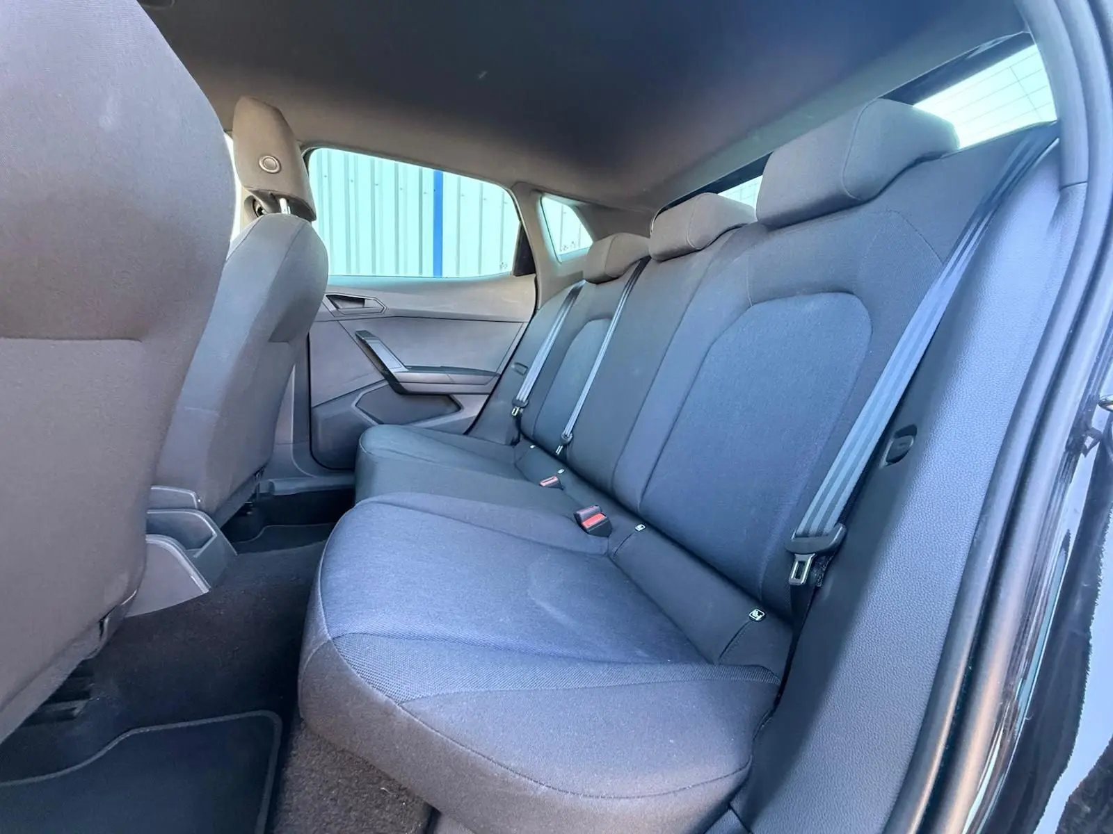 Vue intérieure côté droit sur la banquette arrière noire du SEAT Ibiza 1.0 TSI 95 FR avec ceinture de sécurité visible.