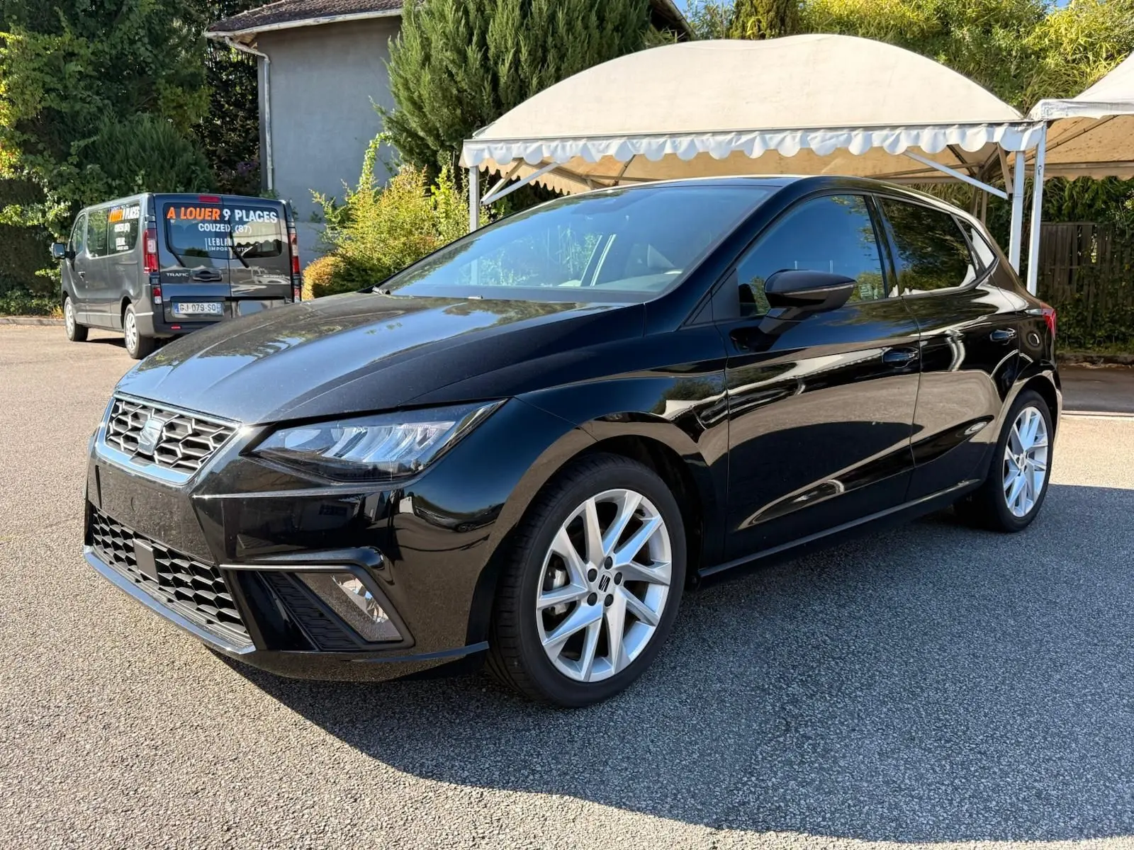 Vue 3/4 avant droite d'une SEAT Ibiza noire 2025 avec jantes alliage et phares LED distinctifs.