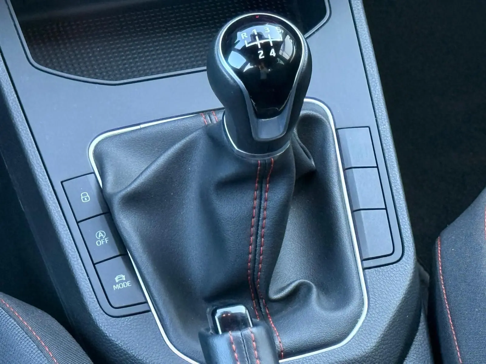 Gros plan sur le levier de vitesses manuel noir avec surpiqûres rouges de la SEAT Ibiza 1.0 TSI 95 FR 2025.