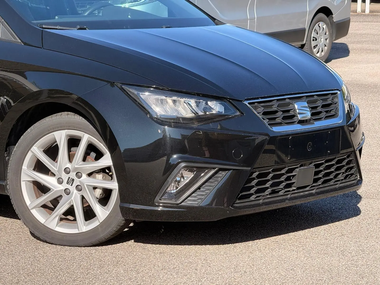 Vue 3/4 avant gauche d'une SEAT Ibiza 2025 noire, avec phares LED et jantes alliage argentées.