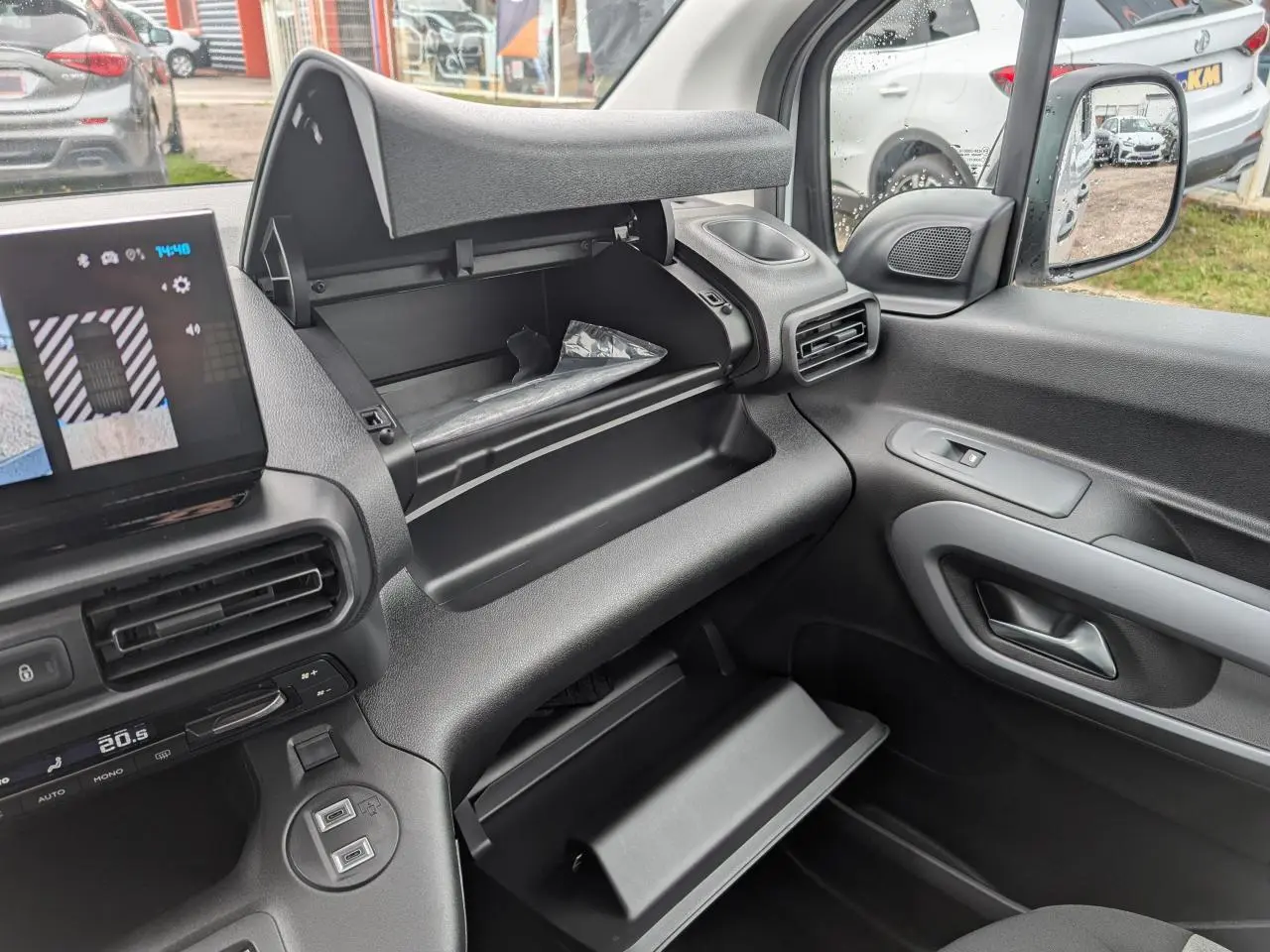 Vue intérieure côté passager du Citroën Berlingo 2025 avec double boîte à gants ouverte et tableau de bord noir.