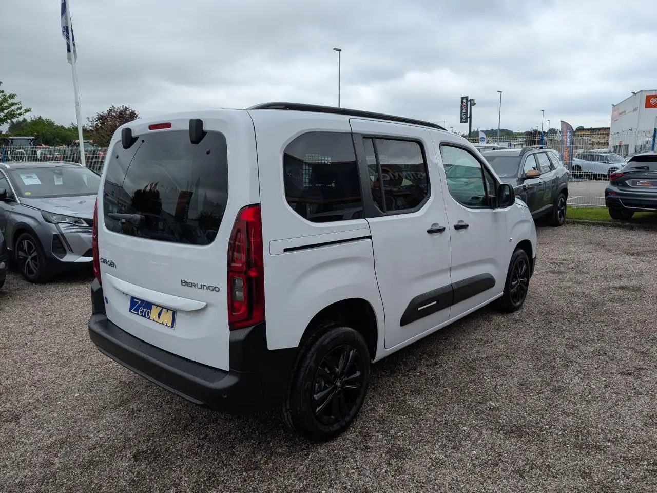 Vue 3/4 arrière droite d'un Citroën Berlingo blanc avec vitres surteintées et jantes alliage noires.
