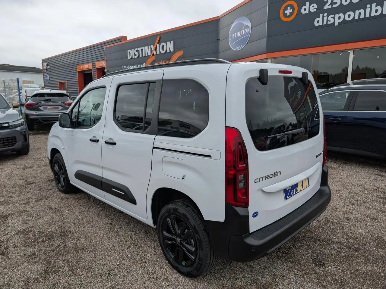 Vue 3/4 arrière droite d'un Citroën Berlingo blanc Kaolin avec jantes alliage noires et vitres surteintées.
