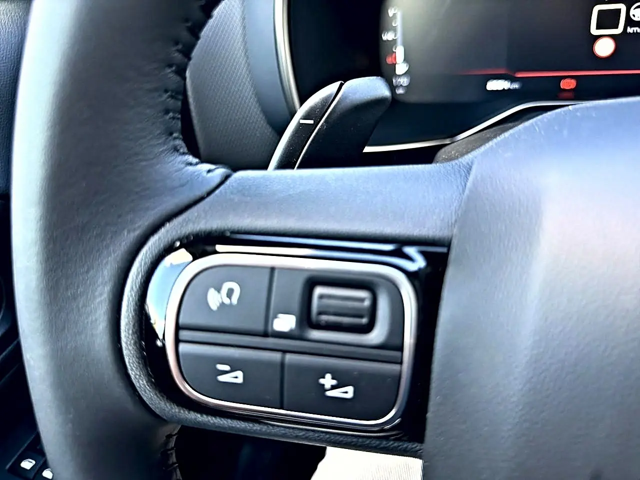 Gros plan sur les commandes multifonctions gauche du volant cuir du Citroën C5 Aircross 2025 blanc.