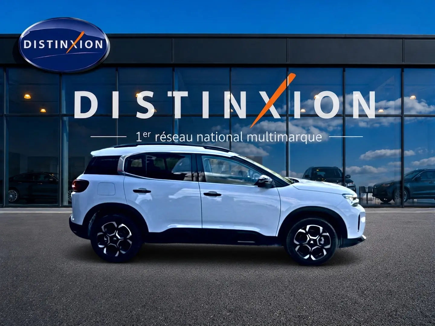 Vue latérale droite d'un Citroën C5 Aircross blanc 2025 avec jantes alu et barres de toit noires.