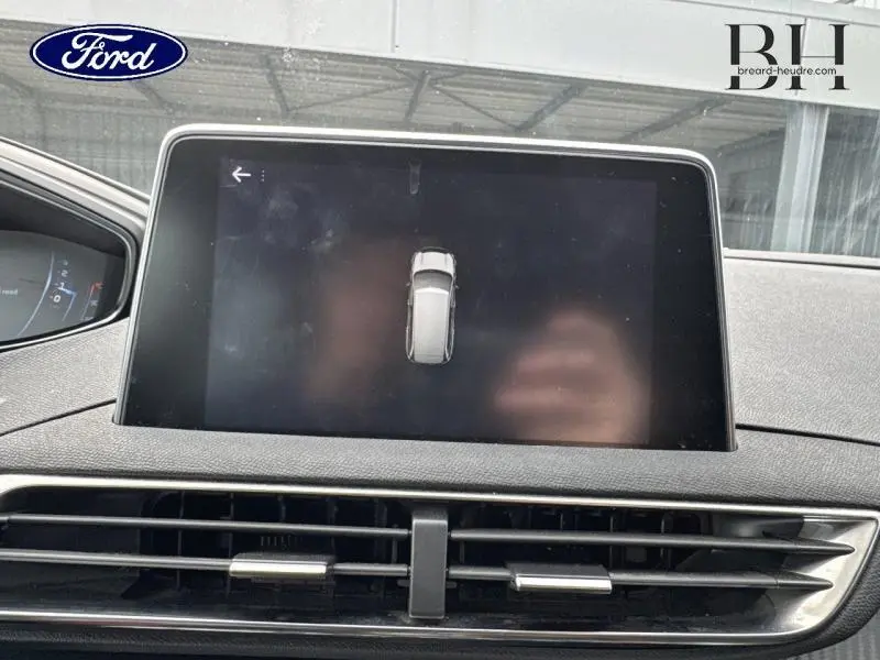 Écran tactile central du tableau de bord du Peugeot 5008 gris Artense, avec affichage de la vue aérienne du véhicule.