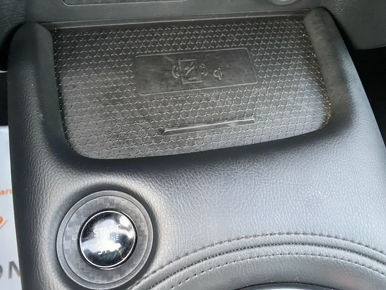 Gros plan sur le bouton Start/Stop noir entouré de cuir noir dans l’habitacle du Nissan Juke 2025.