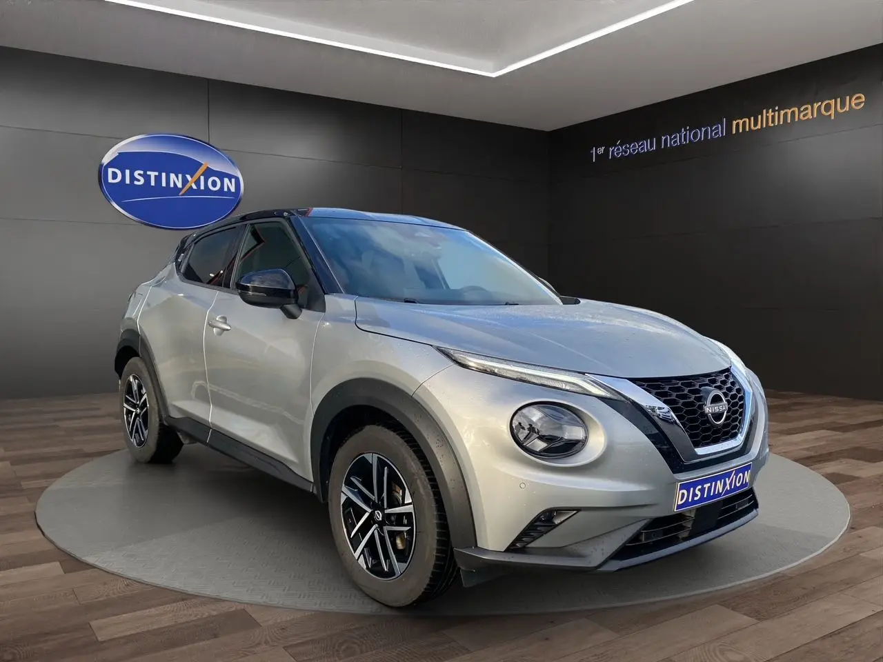 Nissan Juke 2025 gris perle avec toit noir, vue 3/4 avant droit, jantes alliage 17 pouces et calandre distinctive.