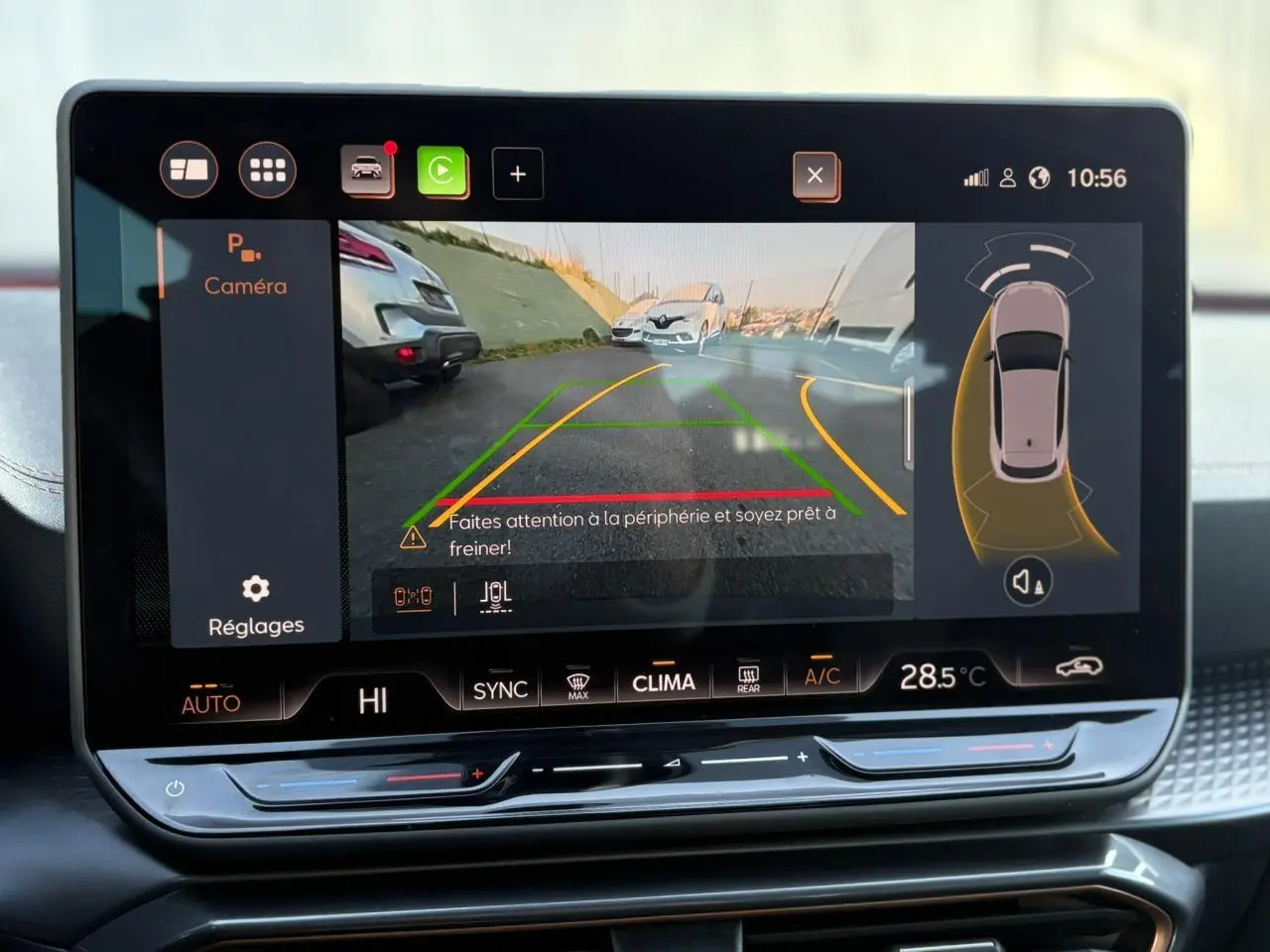 Écran tactile intérieur affichant la caméra de recul et l’aide au stationnement du CUPRA Leon blanc Neige.
