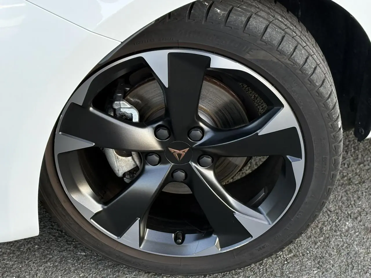 Gros plan sur la jante alliage 18'' Performance usinée noire et grise du CUPRA Leon blanc Neige 2025.