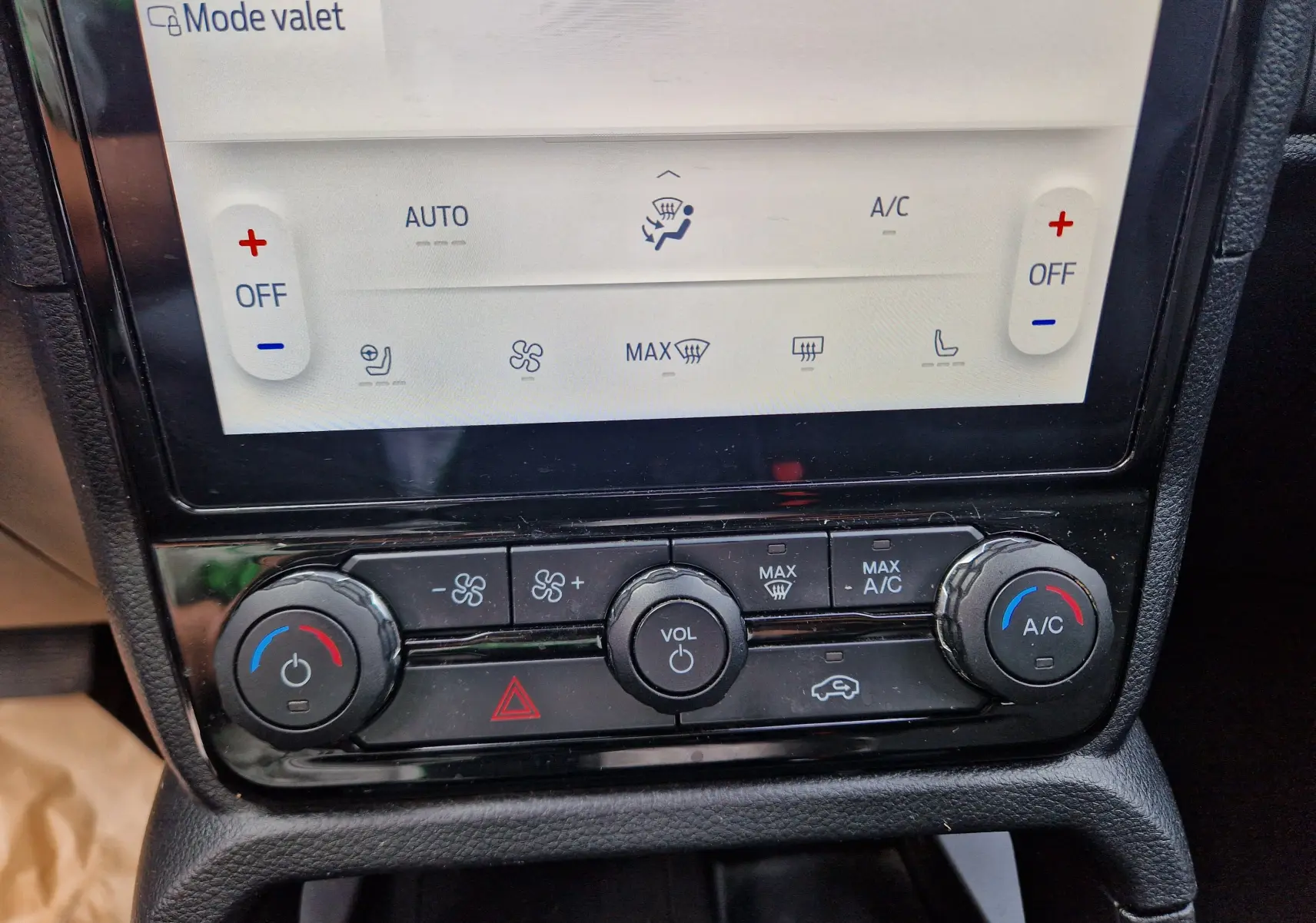 Gros plan sur la console centrale du Ford Ranger Wildtrak 2023, montrant les commandes de climatisation et volume.