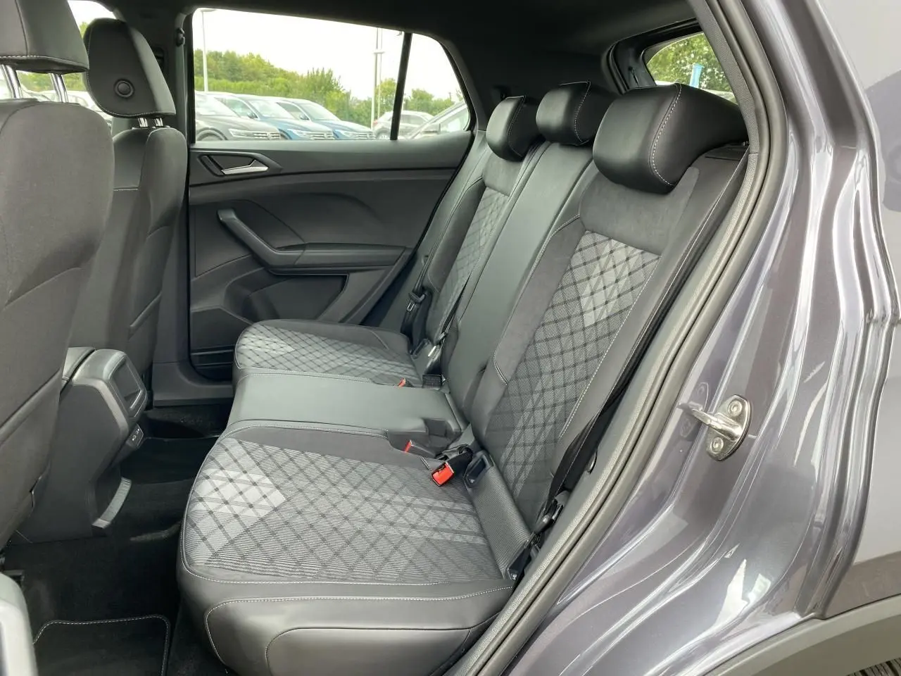 Vue côté droit de la banquette arrière grise à motifs géométriques du Volkswagen T-Cross 2024 avec porte ouverte.