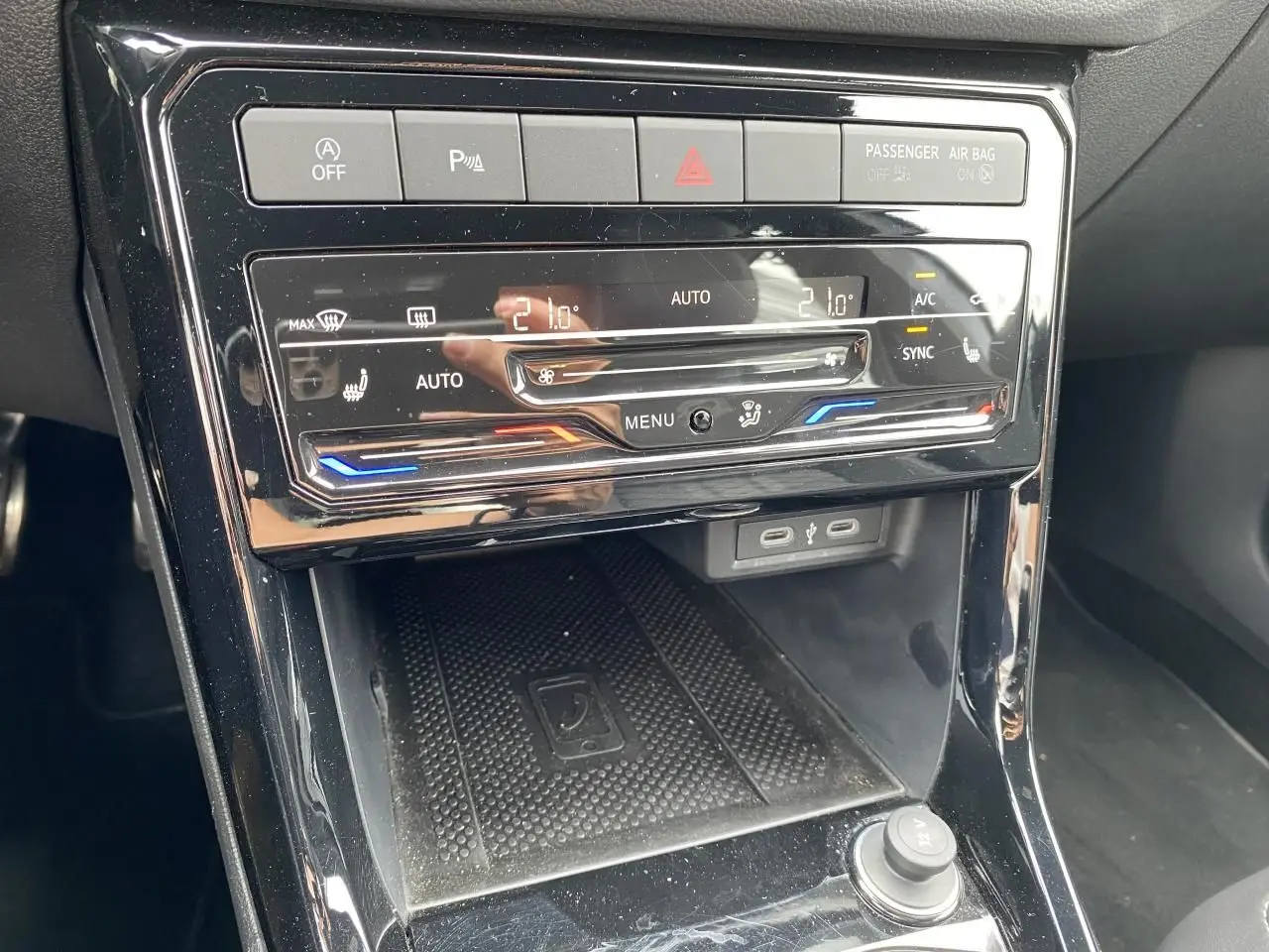 Vue rapprochée de la console centrale noire du Volkswagen T-Cross avec commandes climatisation tactile et ports USB-C.