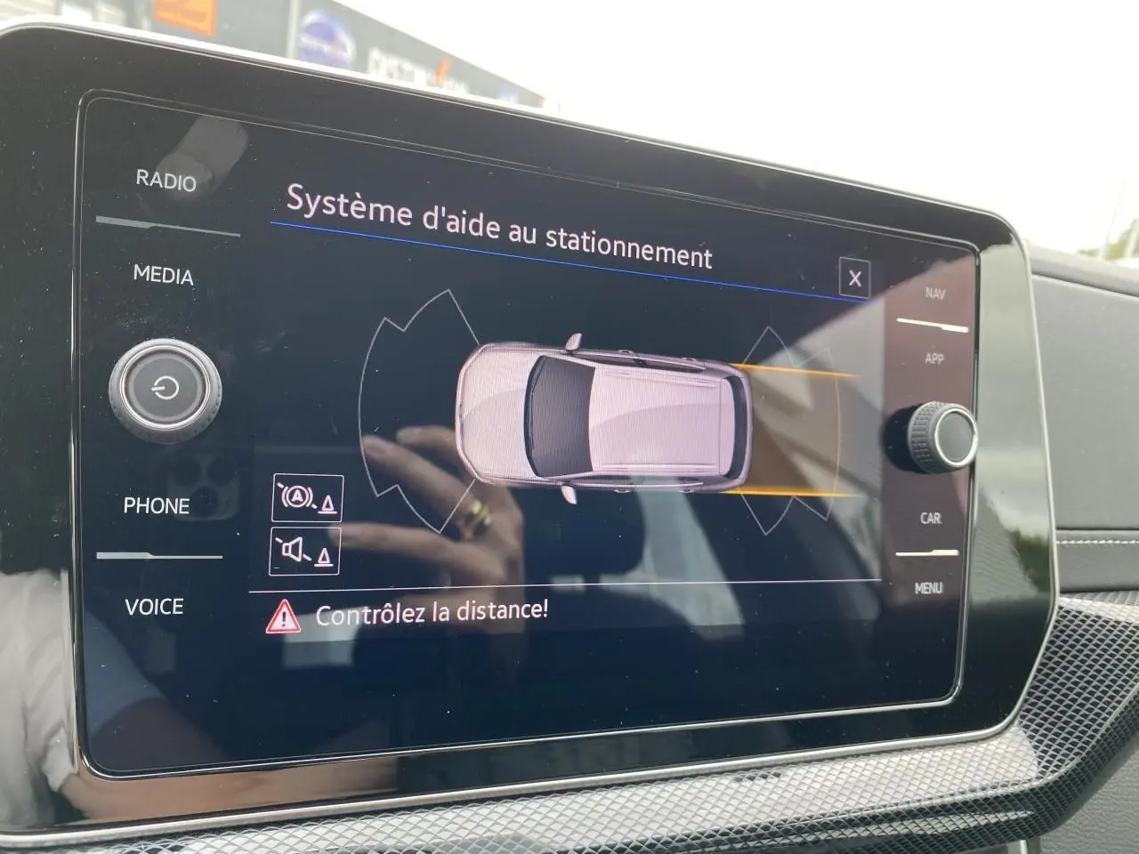 Écran tactile intérieur du Volkswagen T-Cross gris montrant le système d'aide au stationnement.