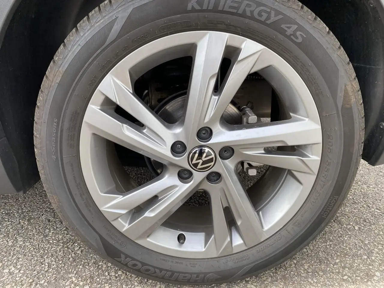 Gros plan sur la jante alliage grise avec logo Volkswagen du Volkswagen T-Cross 2024, pneu Hankook 4 saisons.
