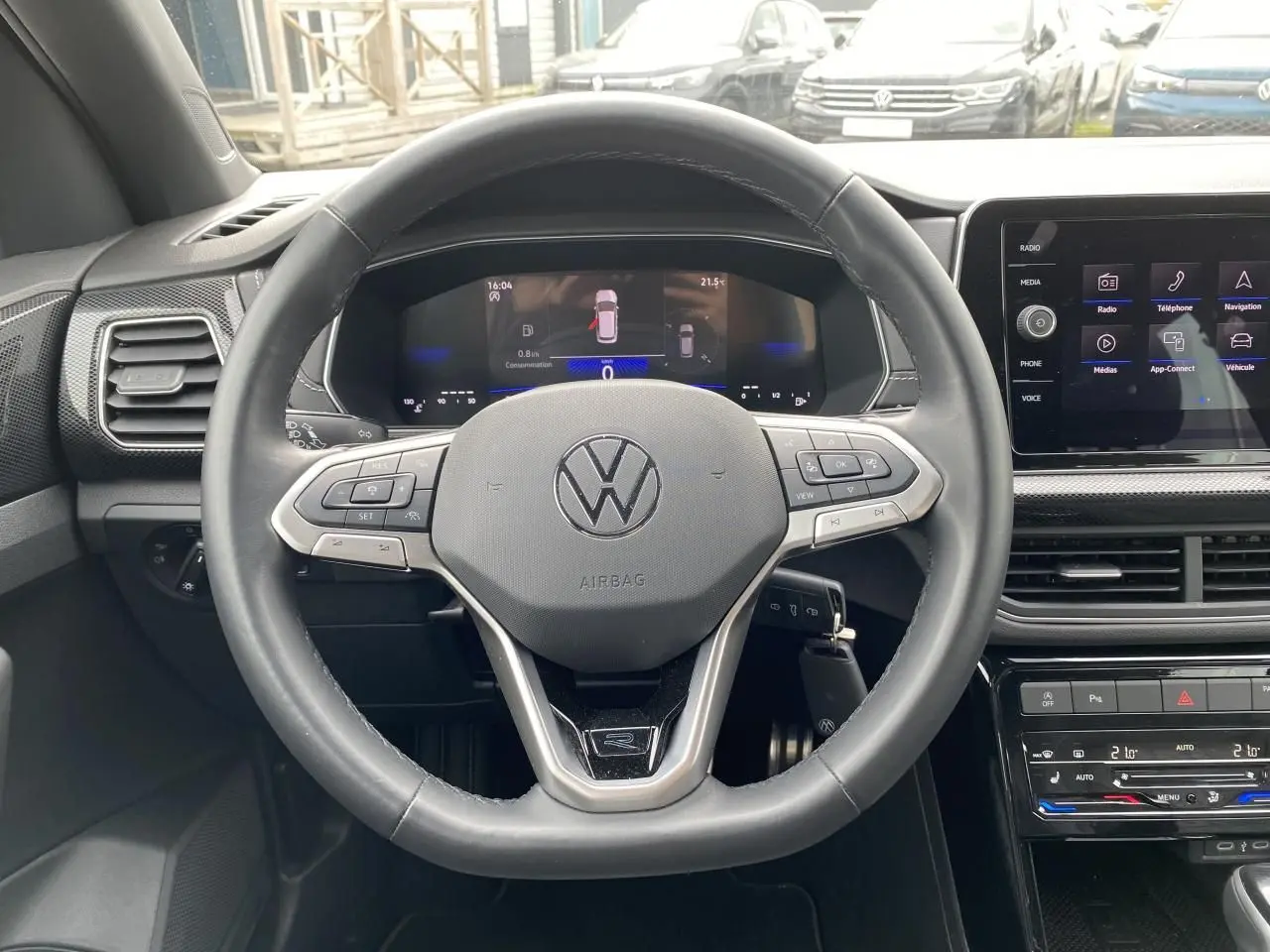 Vue intérieure centrée sur le volant cuir multifonction du Volkswagen T-Cross 2024 avec tableau de bord digital.