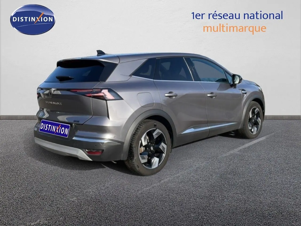 Vue 3/4 arrière droite d’un Renault Symbioz gris cassiopée métallisé avec jantes noires et détails modernes.