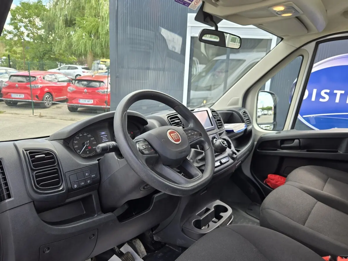 Vue intérieure côté conducteur du Fiat Ducato Fourgon 2022, volant noir avec tableau de bord et écran tactile central.