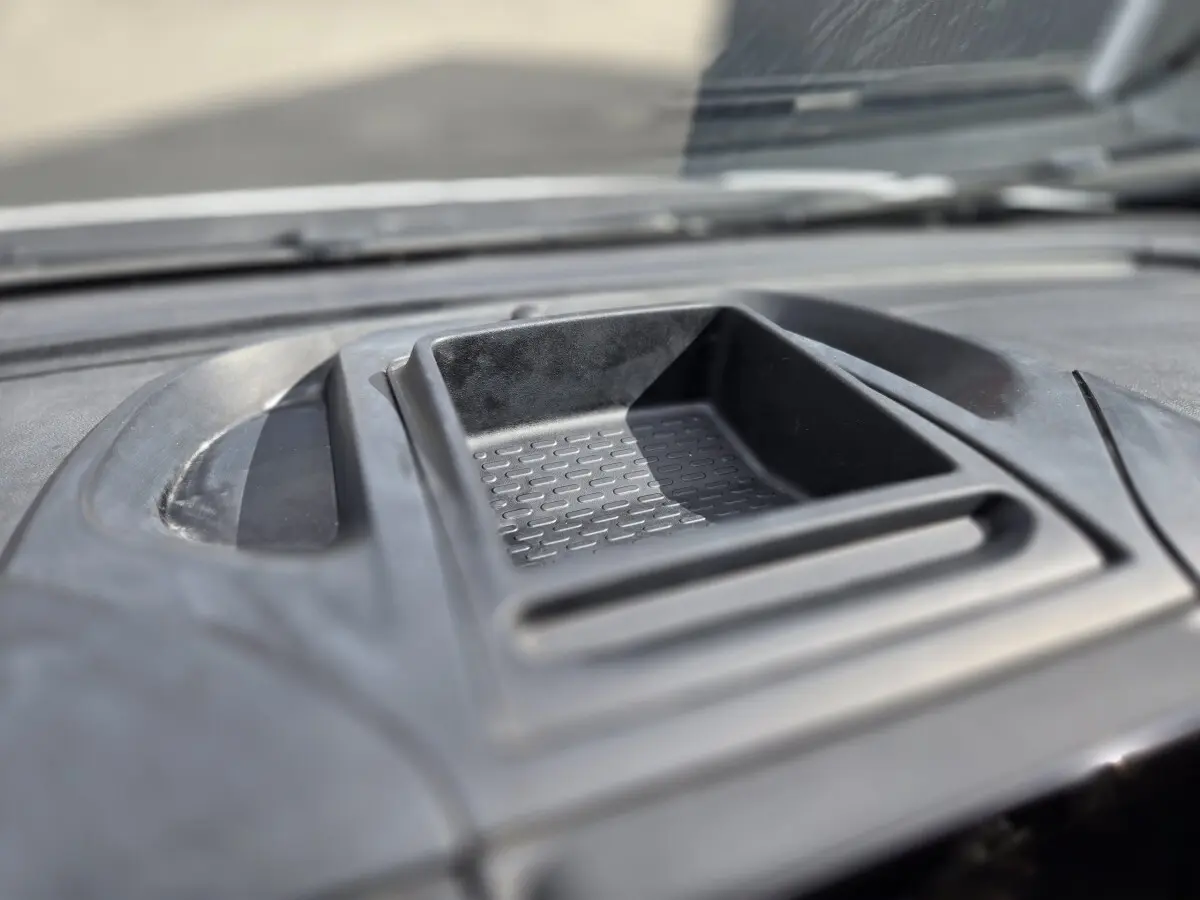 Gros plan sur le rangement central en plastique noir du tableau de bord du Fiat Ducato Fourgon blanc, intérieur lumineux.
