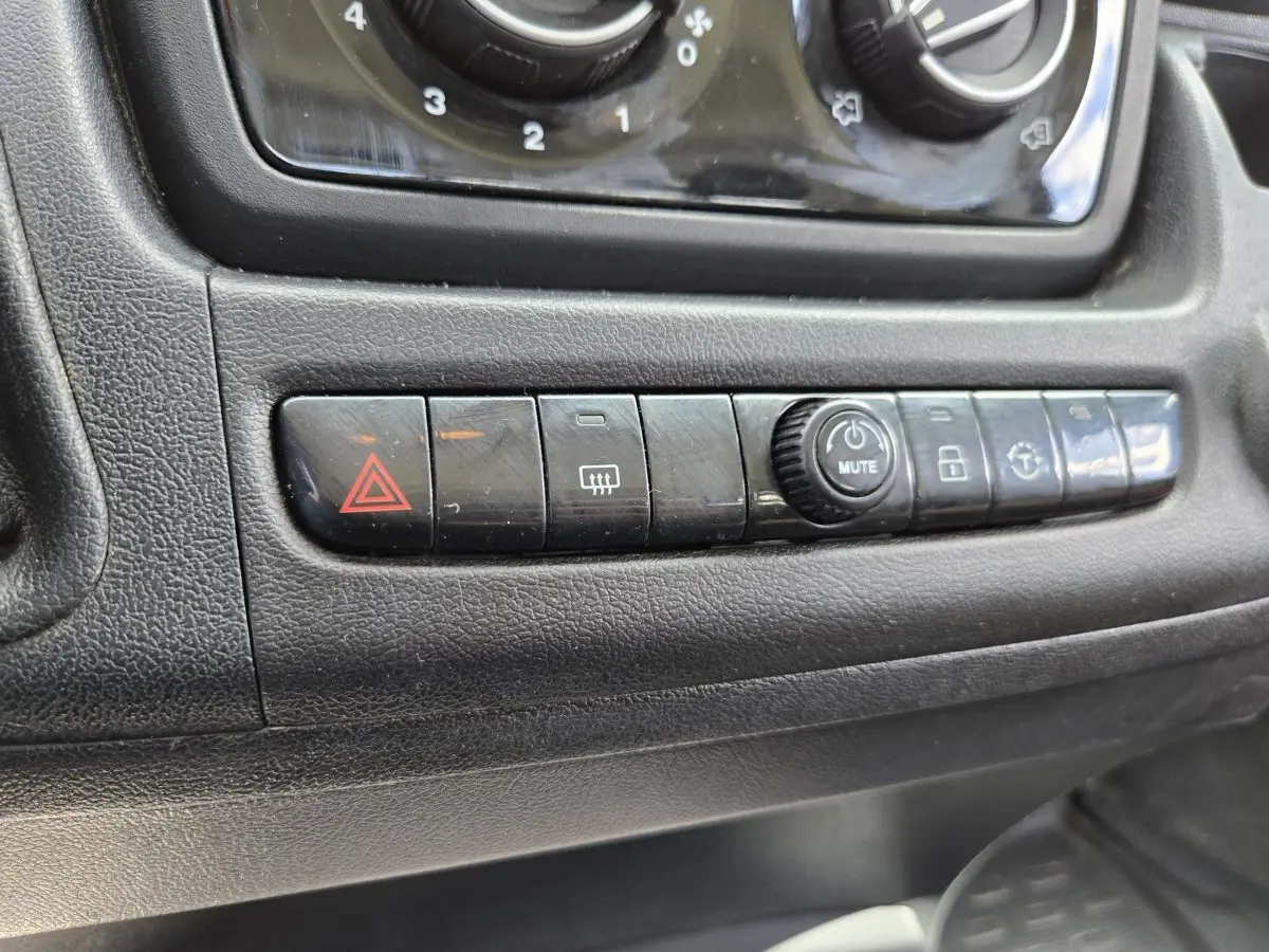 Gros plan sur la rangée de boutons de commande noirs du tableau de bord du Fiat Ducato Fourgon blanc, version 2022.