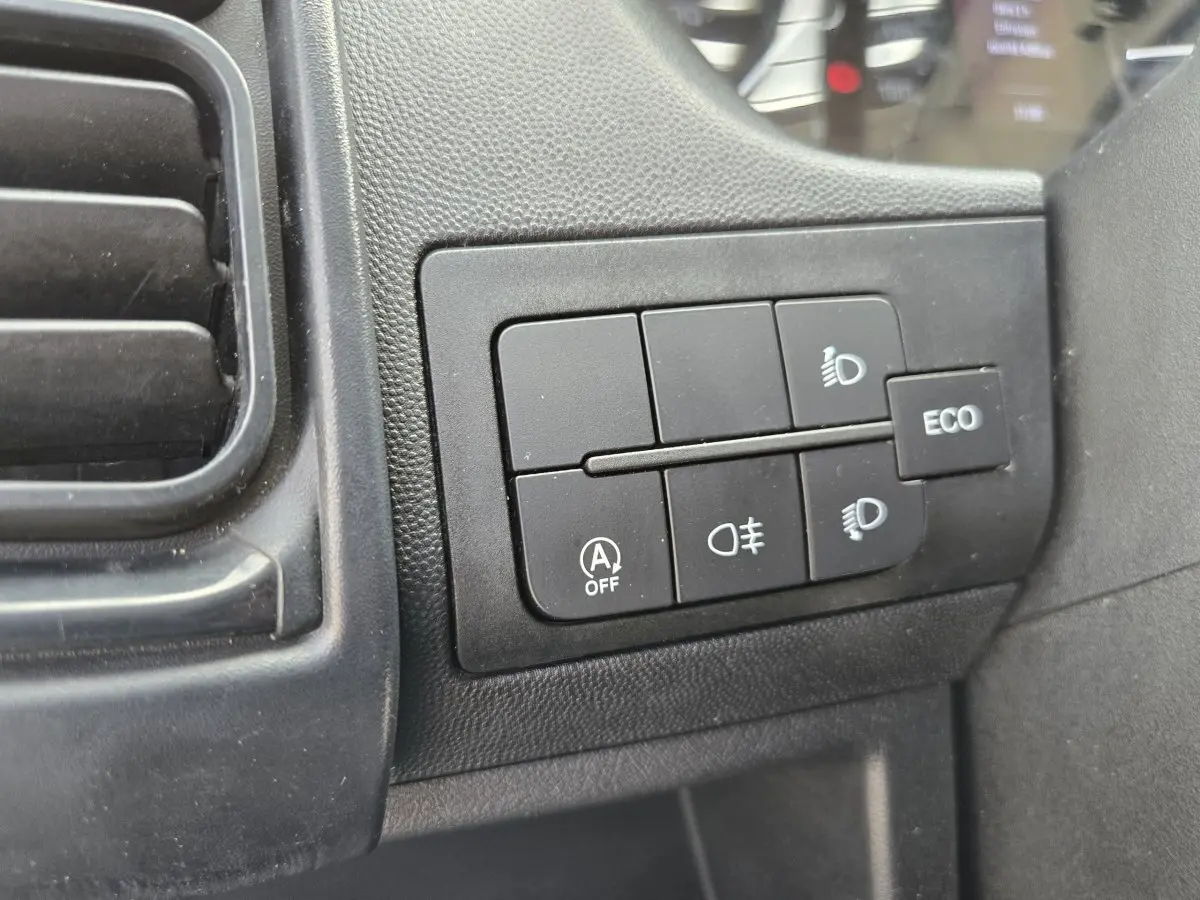 Gros plan sur les commandes d’éclairage et bouton ECO du tableau de bord du Fiat Ducato Fourgon blanc.