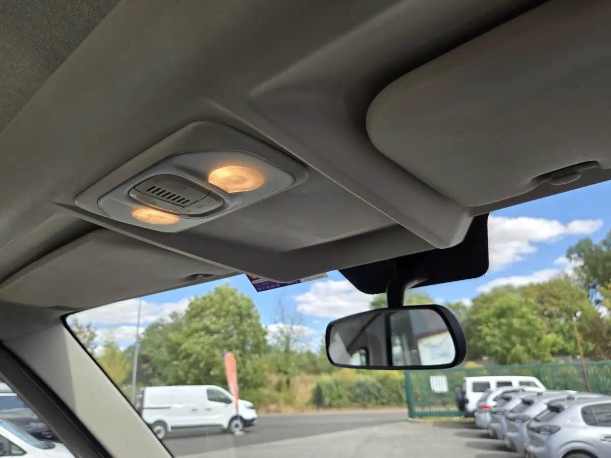 Vue intérieure du plafond et du rétroviseur central d’un FIAT Ducato Fourgon blanc visible à l’extérieur par la vitre avant.