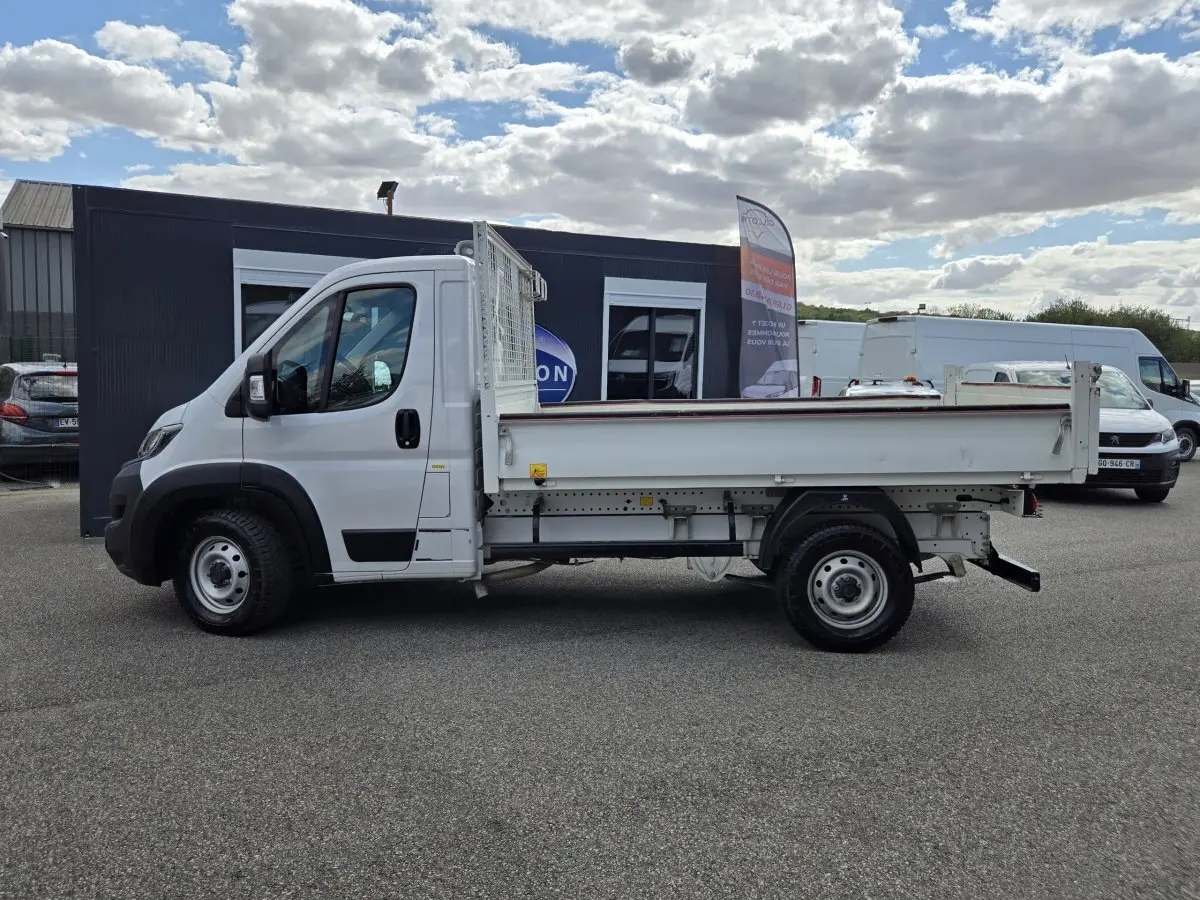 Vue latérale droite d’un FIAT Ducato Fourgon blanc 2022 avec benne plate et cabine simple, stationné en extérieur.