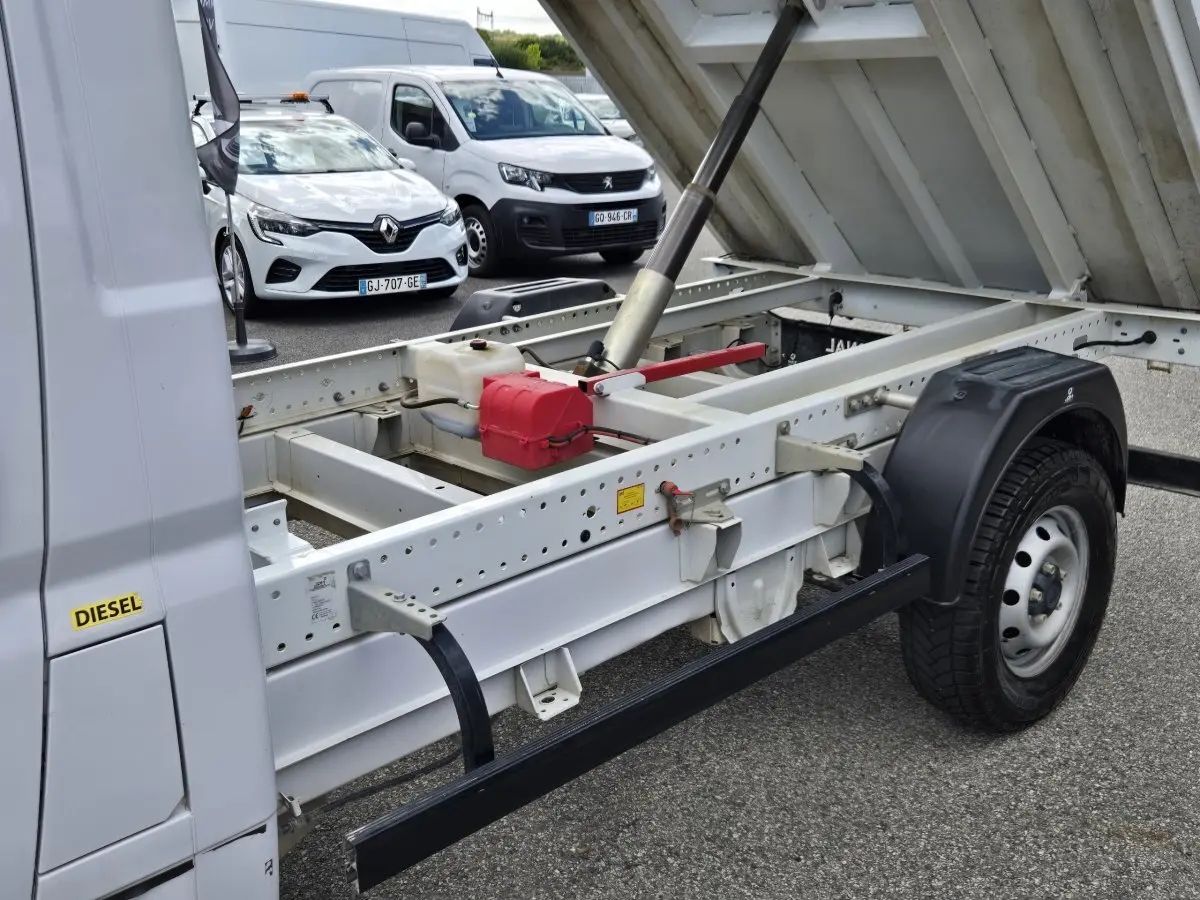 Vue latérale droite du FIAT Ducato Fourgon blanc 2022 avec benne relevée montrant le châssis et le système hydraulique.