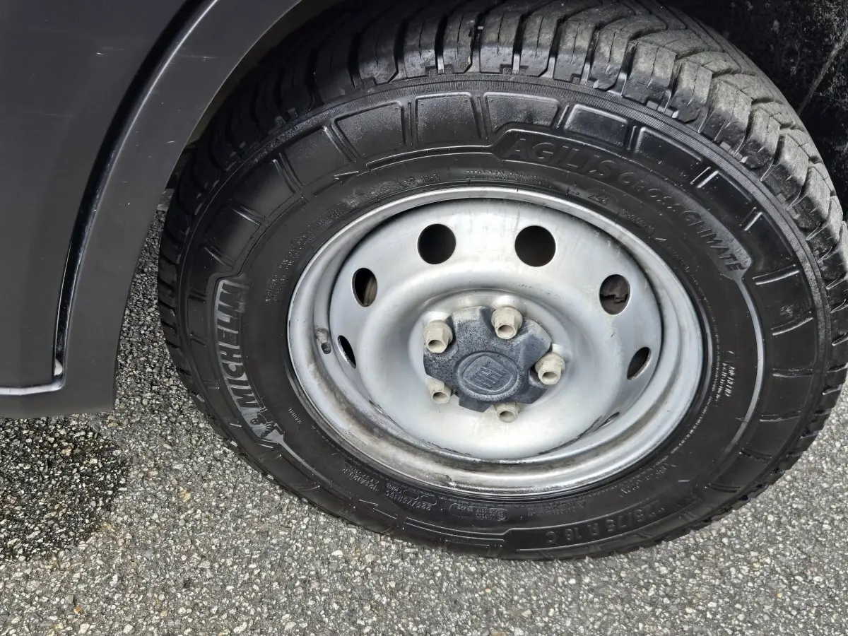 Gros plan sur la roue avant gauche du Fiat Ducato Fourgon blanc, pneu Michelin Agilis CrossClimate visible.