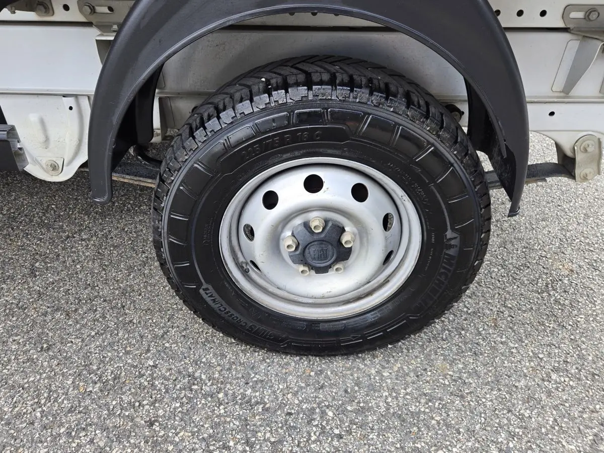 Gros plan sur la roue arrière droite du FIAT Ducato Fourgon blanc, montrant la jante acier et le pneu tout-terrain.