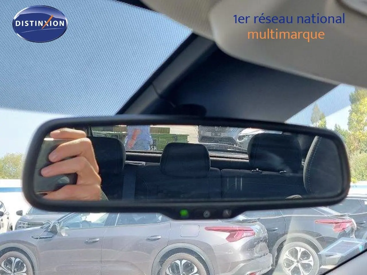 Vue latérale gauche d'un Nissan Qashqai blanc lunaire métal, avec jantes bi-ton 18 pouces visibles sur un parking.