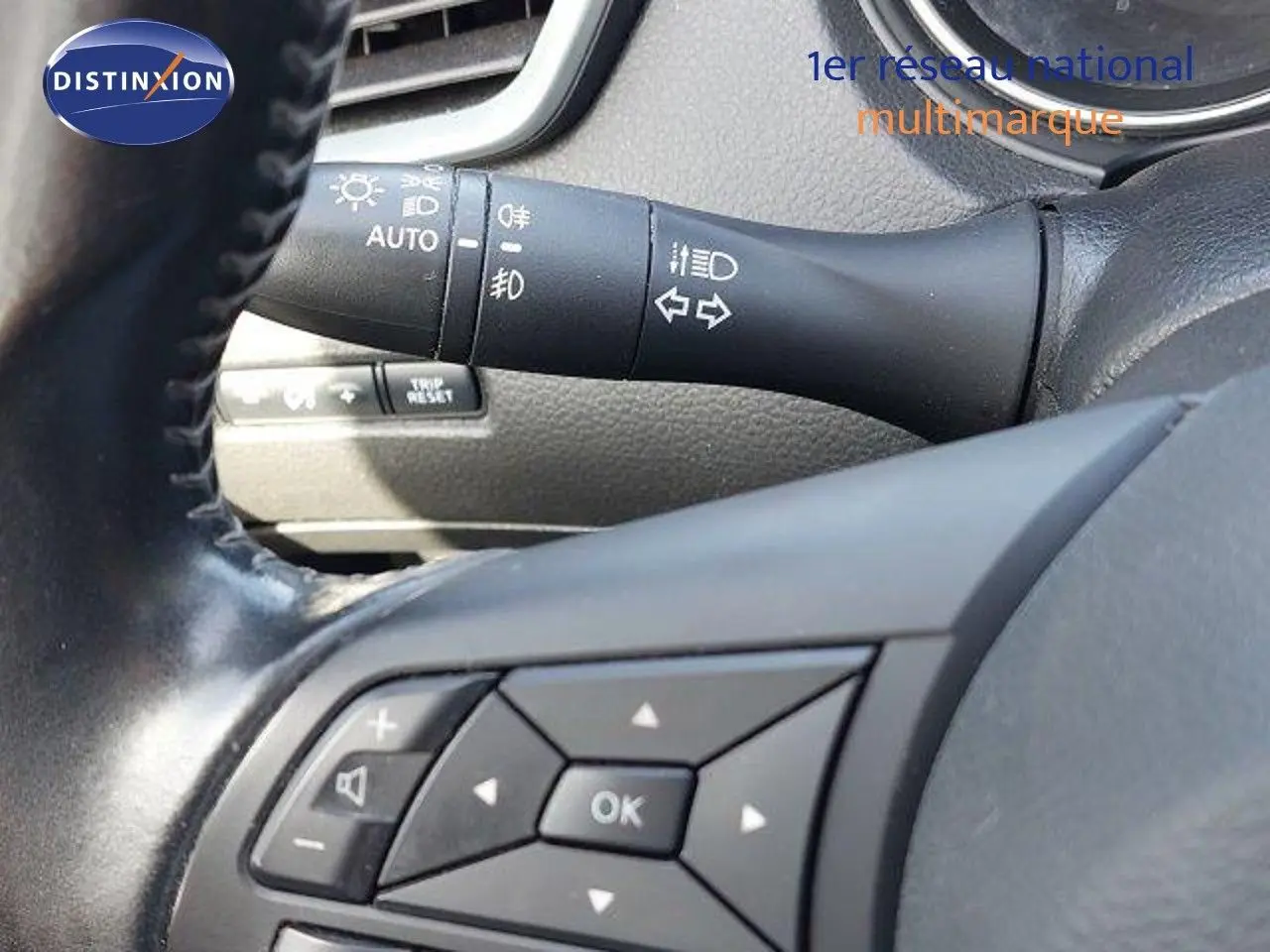 Gros plan sur les commandes au volant et le commodo d'éclairage du Nissan Qashqai blanc lunaire de 2019.