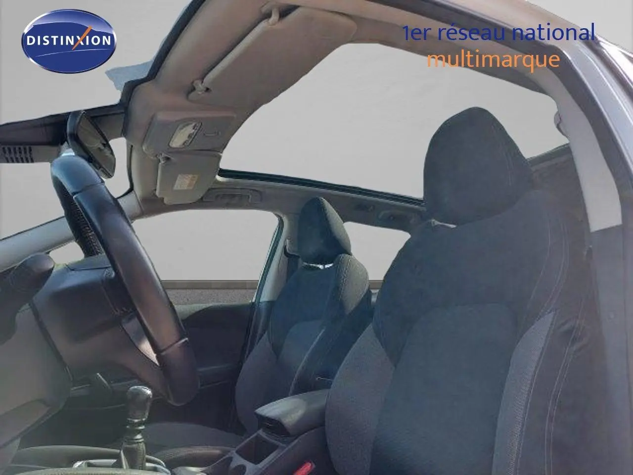 Vue intérieure côté gauche du Nissan Qashqai 2019 blanc lunaire avec sièges tissu gris et toit ouvrant panoramique.