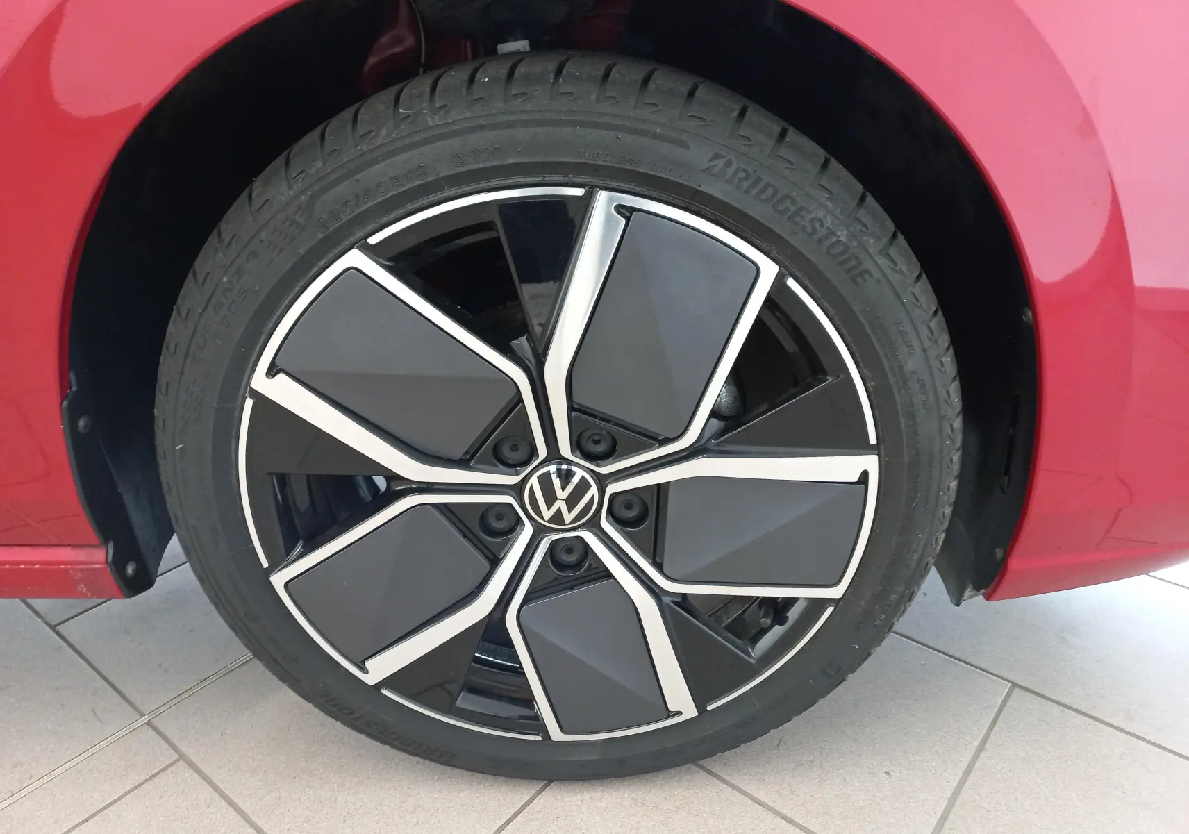 Gros plan sur la jante alliage 18 pouces "Leeds" noire et argentée du Volkswagen Golf Rouge Roi 2024.