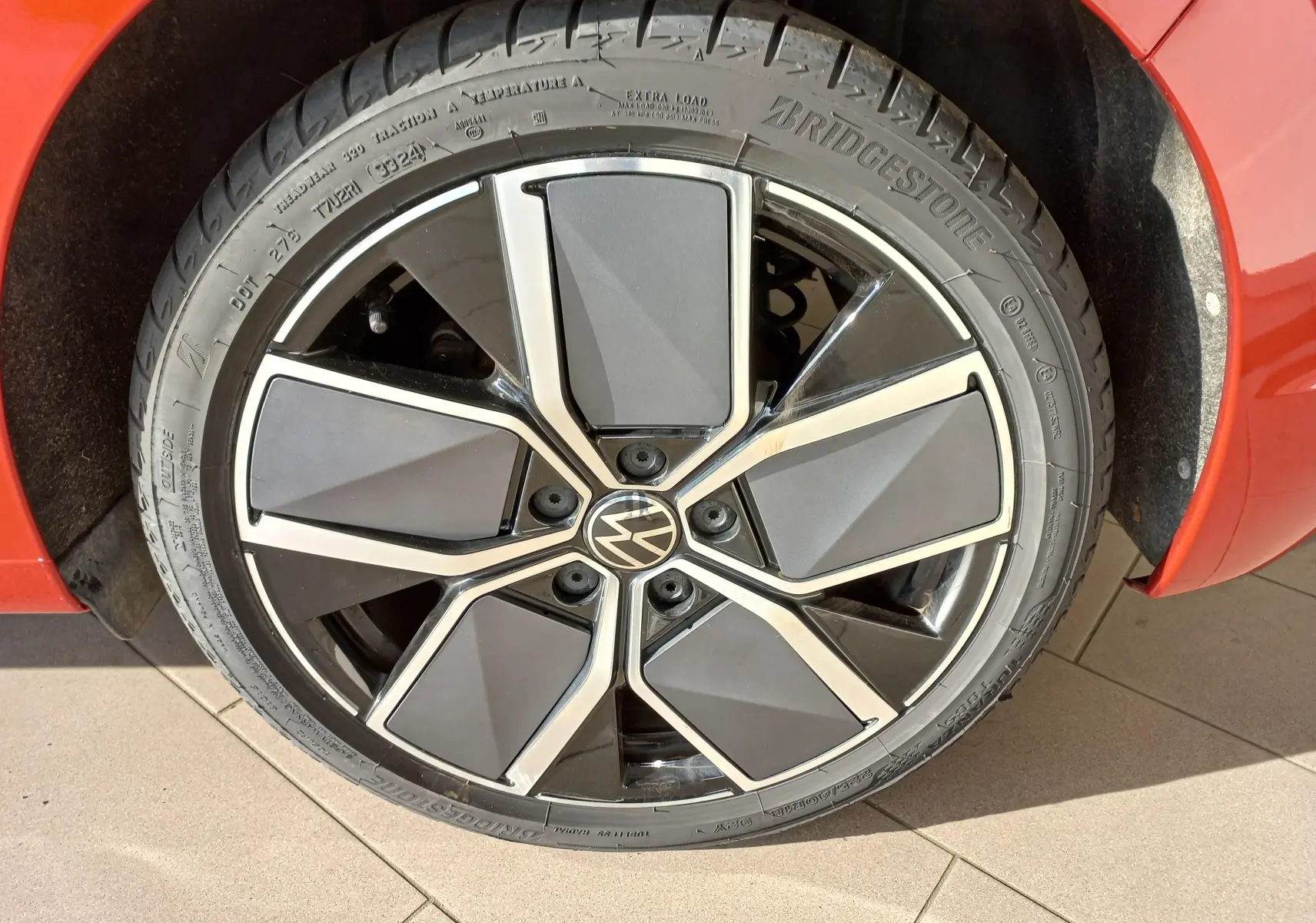 Gros plan sur la jante alliage 18 pouces "Leeds" et pneu Bridgestone du côté gauche d'une Volkswagen Golf Rouge Roi 2024.