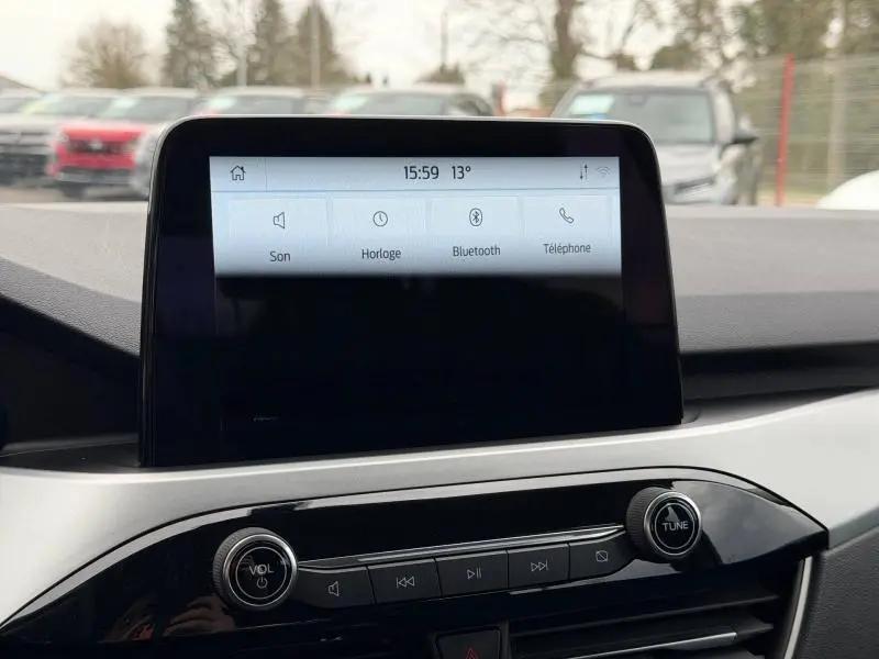 Écran tactile central du tableau de bord du Ford Kuga 2024, affichant les options Son, Horloge, Bluetooth et Téléphone.