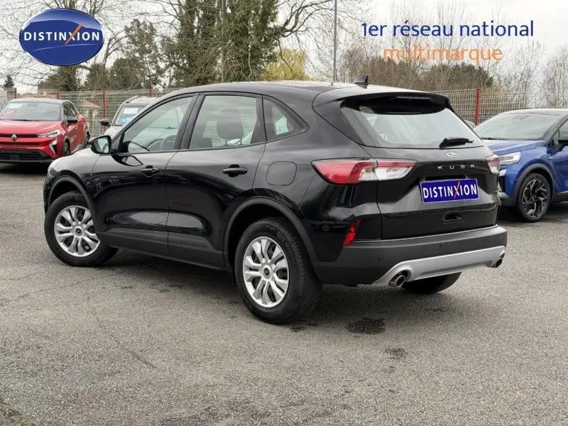 Vue 3/4 arrière droite d'un Ford Kuga 1.5 EcoBoost 150ch Titanium noir brillant, avec jantes alliage et double sortie d'échappement.