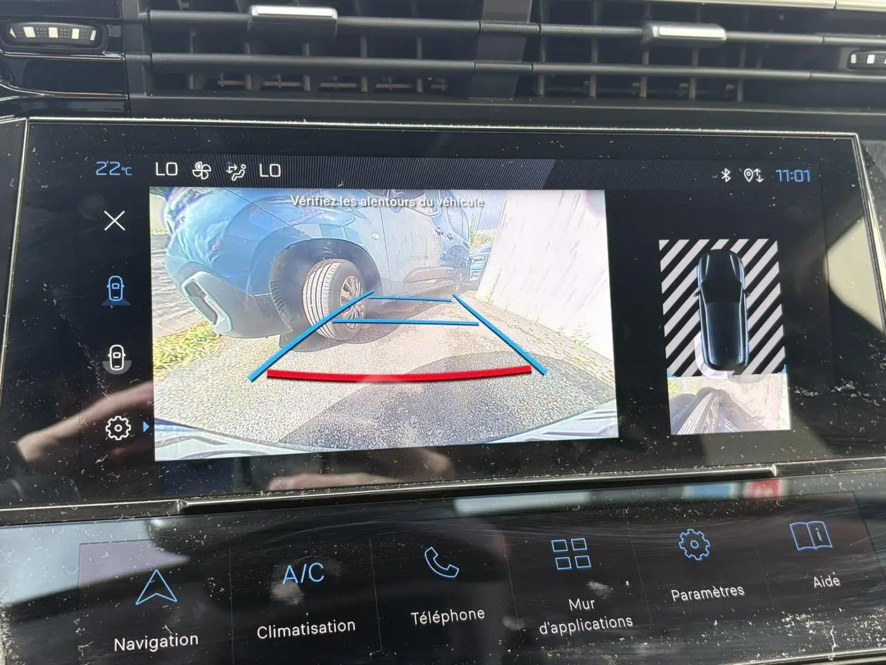 Écran tactile central montrant la caméra de recul avec vue arrière d’une Peugeot 308 Bleu Obsession en stationnement.