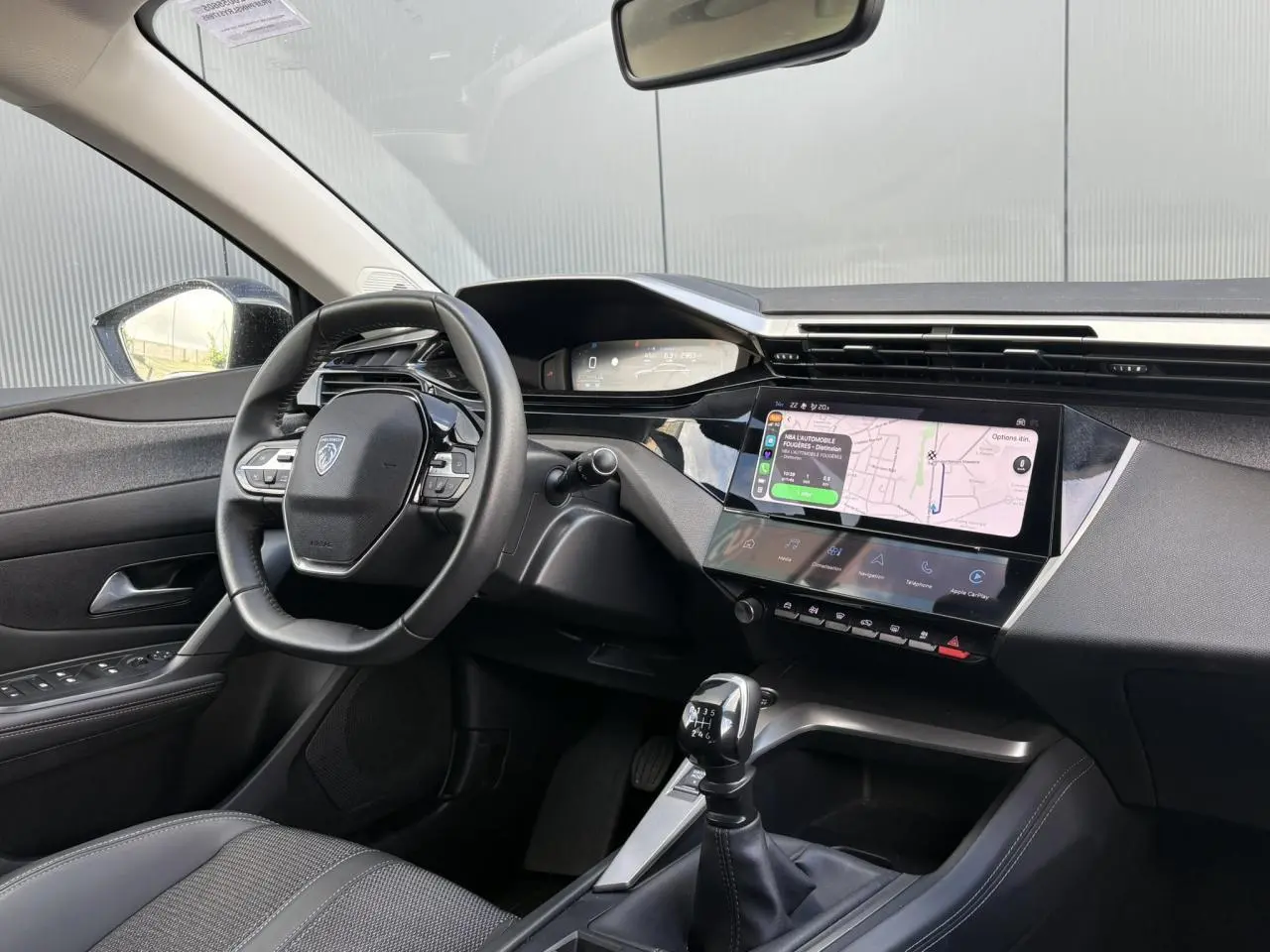 Intérieur Peugeot 308 2024 vue côté conducteur, volant cuir, écran tactile 10'' avec navigation et boîte manuelle.