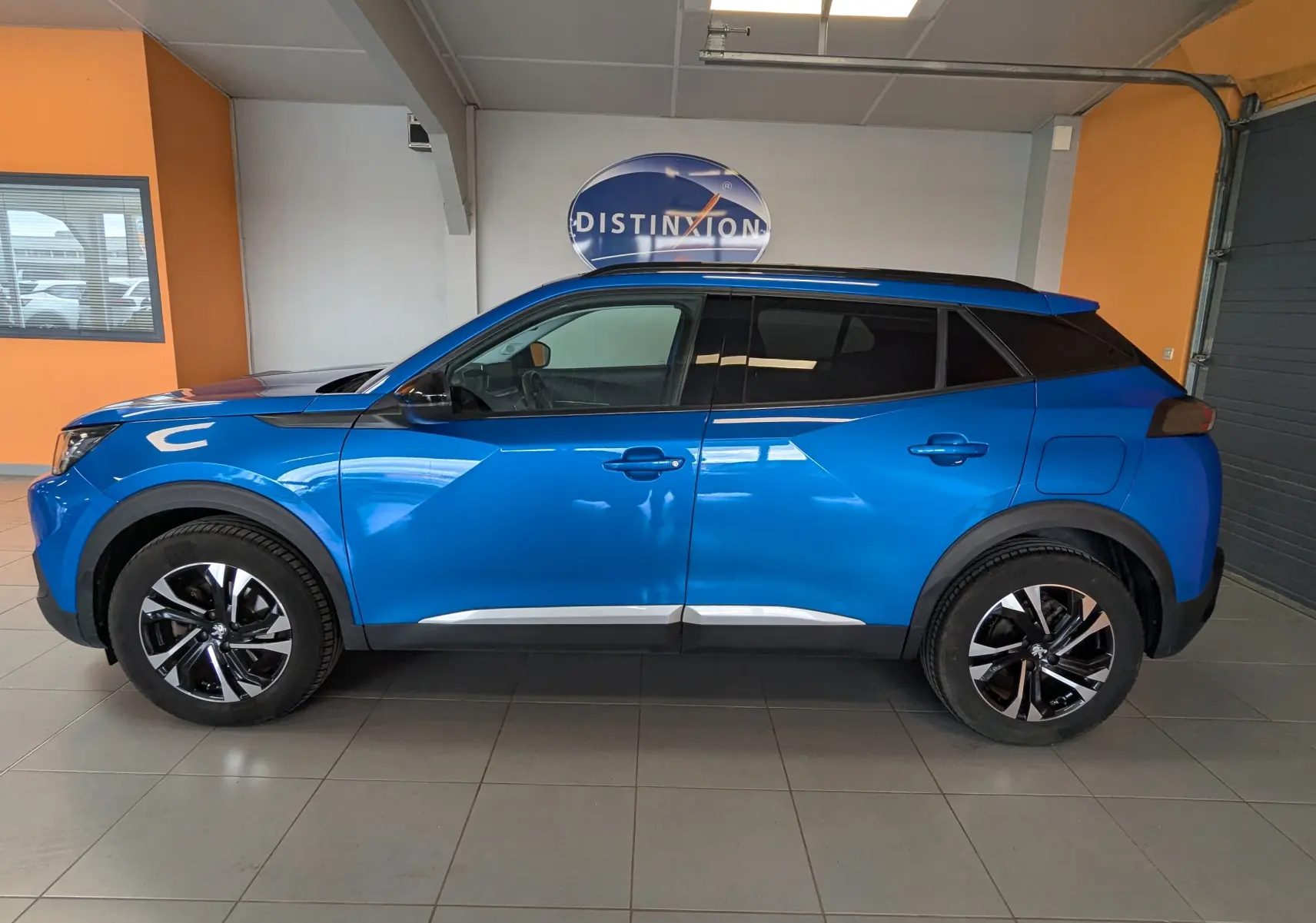 Peugeot 2008 1.5 BlueHDi 130 Allure bleu vue de profil côté gauche, avec jantes bi-ton et toit noir.