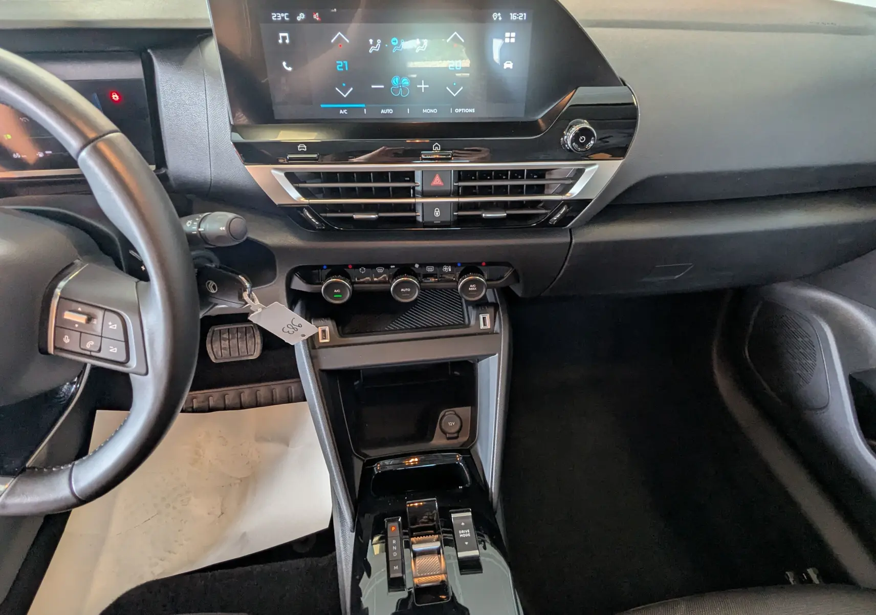 Vue intérieure avant centrée sur le tableau de bord et console centrale de la Citroën C4 Hybrid 145, écran tactile 10 pouces et commandes climatisation.