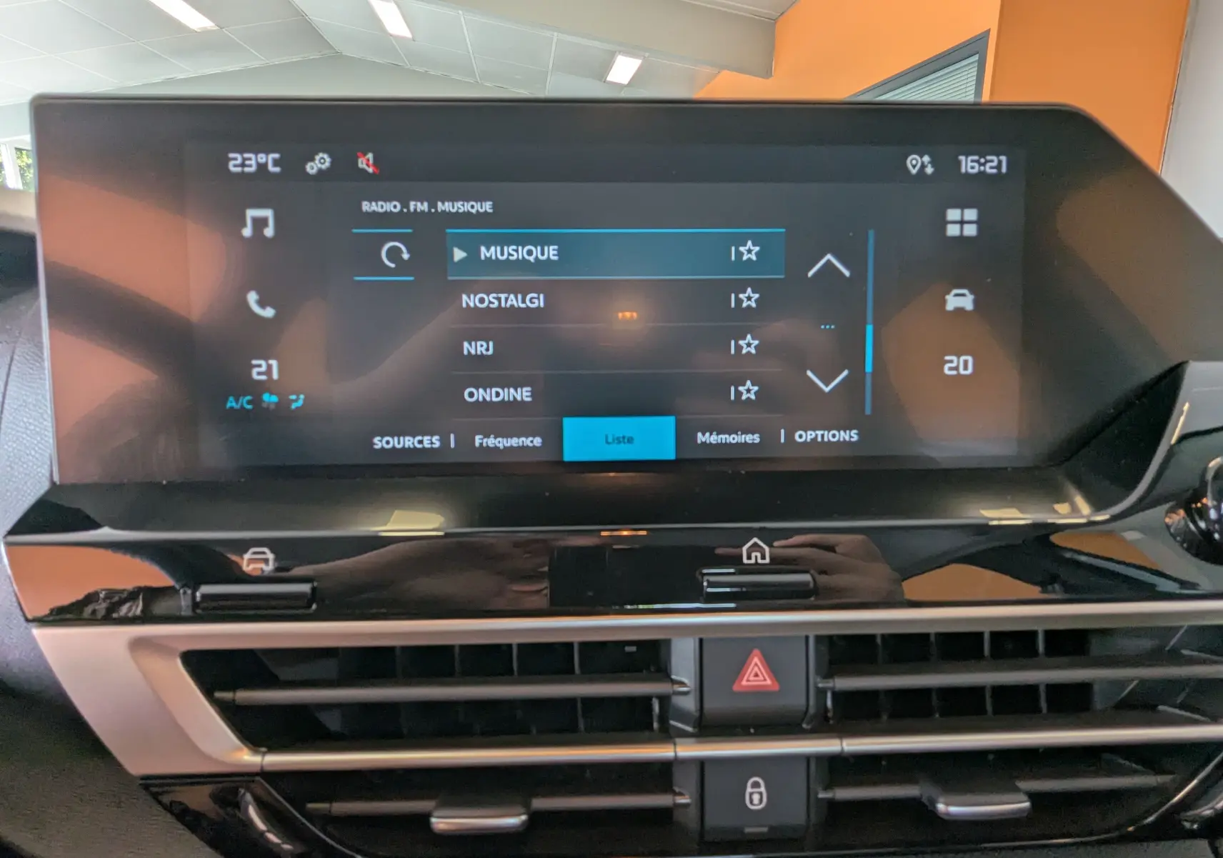 Écran tactile central du tableau de bord de la Citroën C4 Hybrid 145 gris Mercury, affichant les options radio et climatisation.