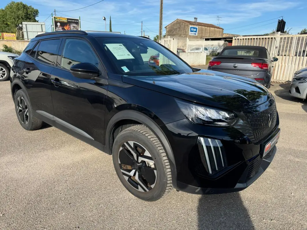 Peugeot 2008 Hybrid noir en 3/4 avant droit, avec barres de toit et jantes alliage 17 pouces visibles.