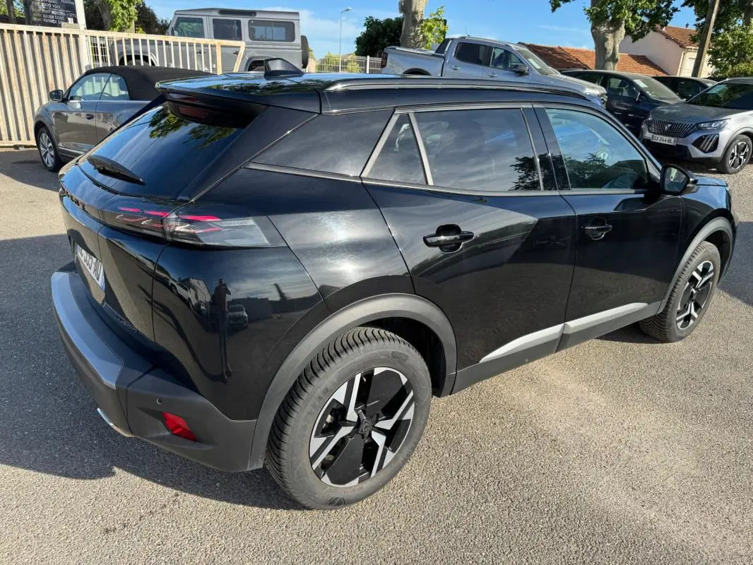 Peugeot 2008 Hybrid noir vue 3/4 arrière droit, avec barres de toit et jantes alliage 17 pouces.
