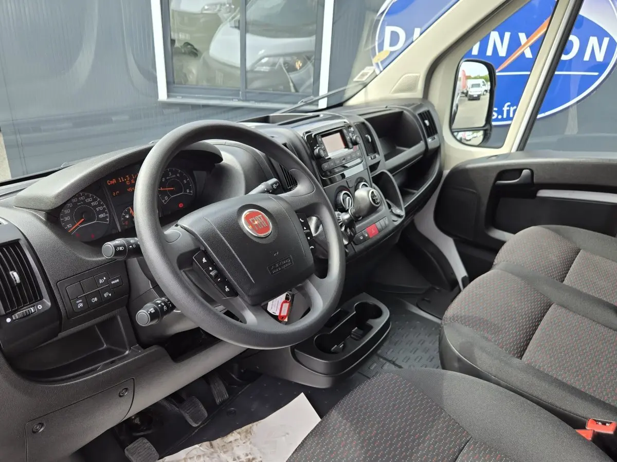 Intérieur du FIAT Ducato Fourgon blanc 2023, vue côté conducteur sur le tableau de bord et volant multifonctions.