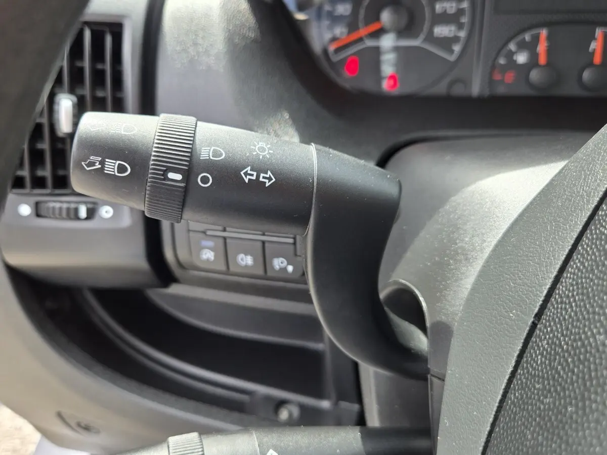 Gros plan sur la manette de clignotant et phare du tableau de bord noir du Fiat Ducato Fourgon 2023.