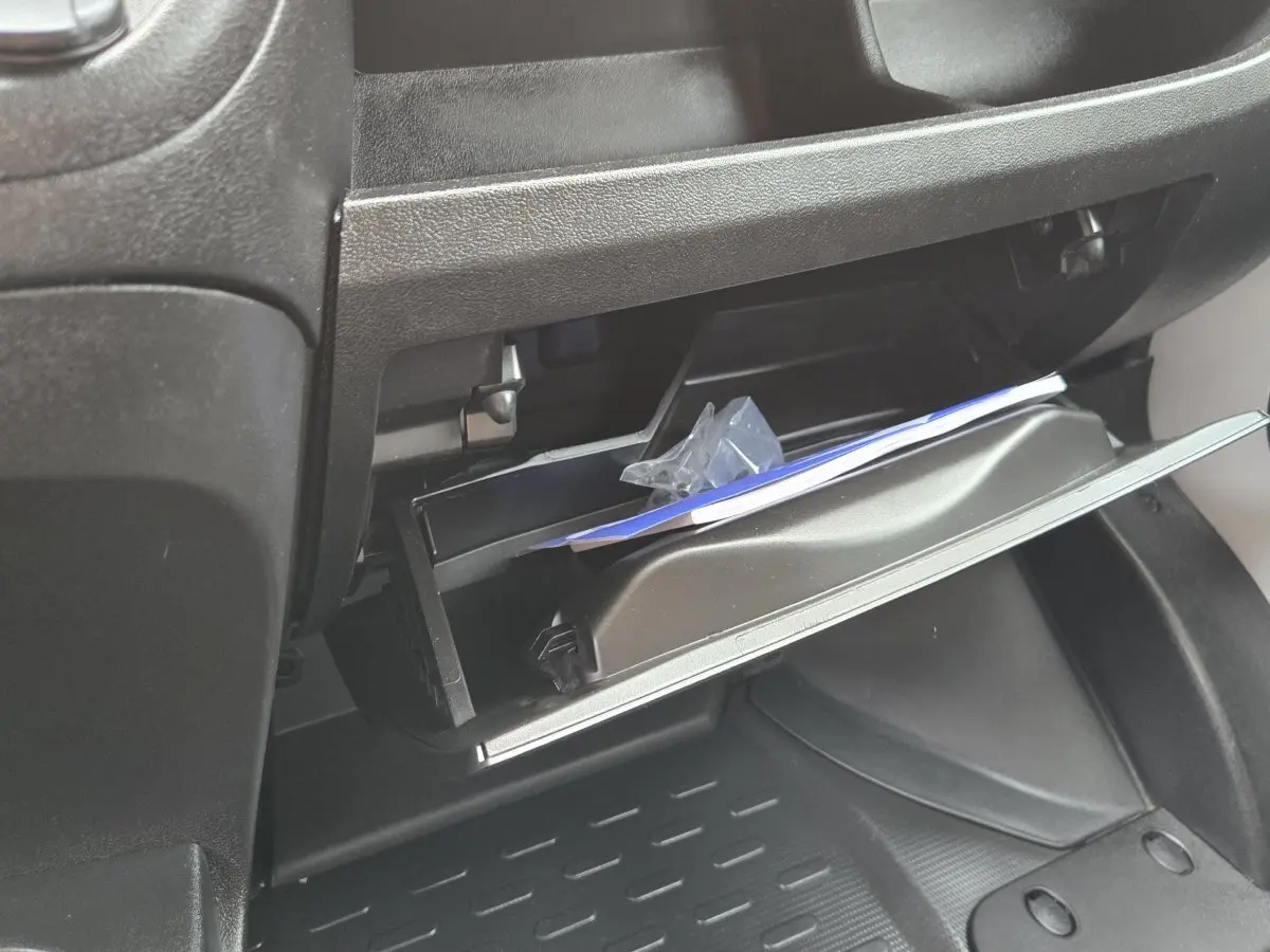 Vue rapprochée de la boîte à gants ouverte du Fiat Ducato Fourgon blanc, montrant l'intérieur et des documents.