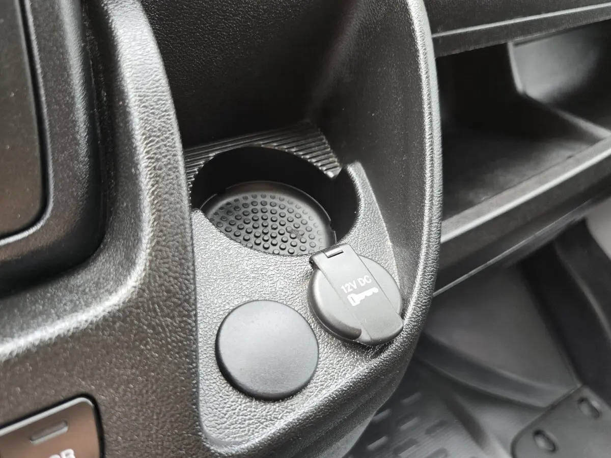 Gros plan sur la prise 12V et porte-gobelet dans l’habitacle noir du Fiat Ducato Fourgon blanc.
