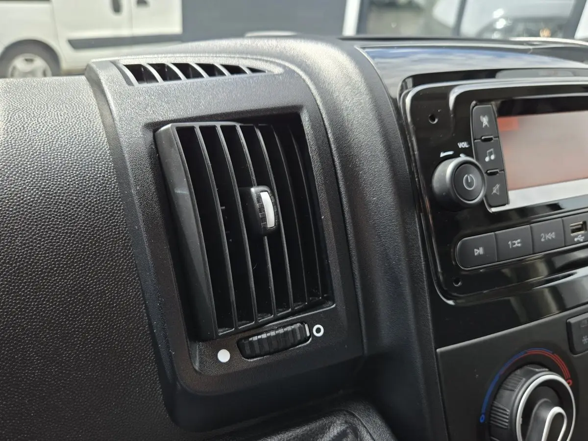 Détail de la ventilation et console centrale noire à l'intérieur du Fiat Ducato Fourgon blanc 2023.