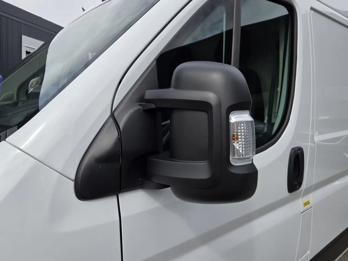 Gros plan sur le rétroviseur droit noir du FIAT Ducato Fourgon blanc, vue latérale avant du véhicule.